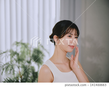 一位年輕女子感到皮膚濕潤 一位年輕女子感到皮膚濕潤 141488663