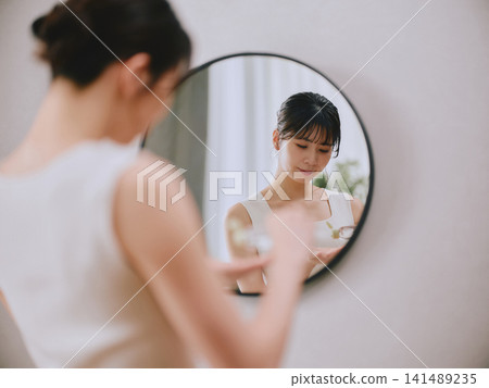 一名年輕女子正在做皮膚護理 一名年輕女子正在做皮膚護理 141489235