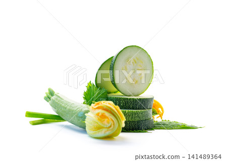 Organic zucchini slices with green leaves on clean white background Organic zucchini slices with green leaves on clean white background 141489364