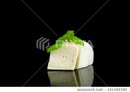 Organic soft white cheese with green basil on glossy black background Organic soft white cheese with green basil on glossy black background 141489390