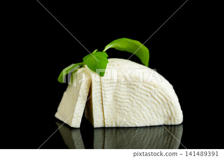 Creamy artisan mozzarella slices with fresh basil on dark background Creamy artisan mozzarella slices with fresh basil on dark background 141489391