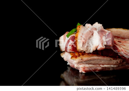 Traditional pork lard with fresh basil on black reflective background Traditional pork lard with fresh basil on black reflective background 141489396