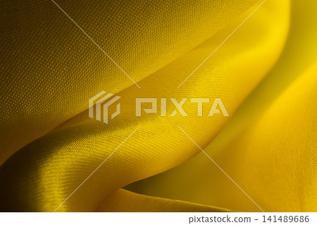 Macro shot of vibrant yellow satin fabric with gentle folds, soft lighting, and smooth texture Macro shot of vibrant yellow satin fabric with gentle folds, soft lighting, and smooth texture 141489686