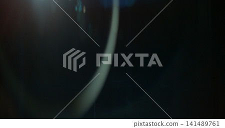 Abstract cinematic lens flare overlay texture featuring soft optical reflections, blue light artifacts and subtle glow on a black background. Premium VFX asset for compositing and film editing. Abstract cinematic lens flare overlay texture featuring soft optical reflections, blue light artifacts and subtle glow on a black background. Premium VFX asset for compositing and film editing. 141489761