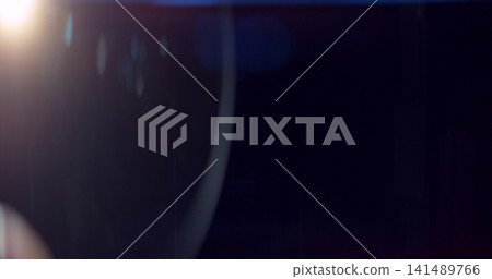 Abstract cinematic lens flare overlay texture featuring soft optical reflections, blue light artifacts and subtle glow on a black background. Premium VFX asset for compositing and film editing. 141489766