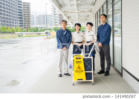 四名清潔人員,兩男一女,在清潔車前排成一排。 四名清潔人員,兩男一女,在清潔車前排成一排。 141490267