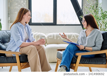 Woman listens intently to her therapist during private session Woman listens intently to her therapist during private session 141490692