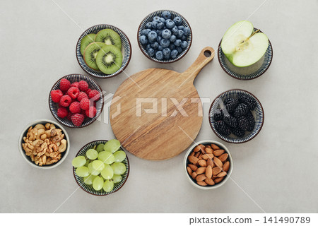 Healthy antioxidant rich fruits, berries and nuts on light background Healthy antioxidant rich fruits, berries and nuts on light background 141490789
