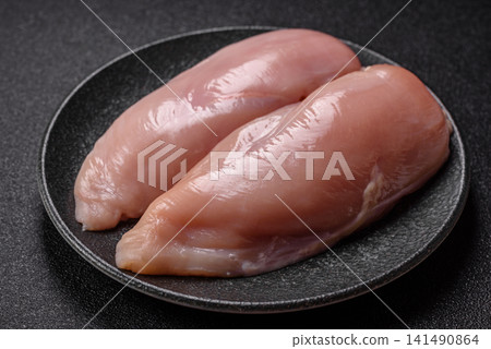 Fresh raw chicken fillet with salt and spices for home cooking. Raw chicken fillet Fresh raw chicken fillet with salt and spices for home cooking. Raw chicken fillet 141490864