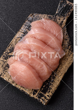 Fresh raw chicken fillet with salt and spices for home cooking. Raw chicken fillet 141490865