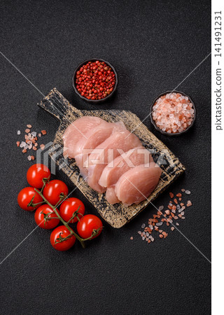 Fresh raw chicken fillet with salt and spices for home cooking. Raw chicken fillet 141491231