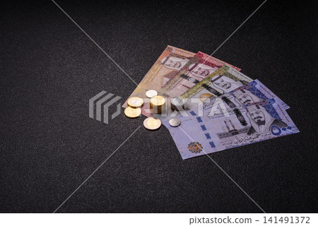 Saudi Arabia paper money, riyal banknotes and coins as currency for exchange. Saudi Arabia money Saudi Arabia paper money, riyal banknotes and coins as currency for exchange. Saudi Arabia money 141491372
