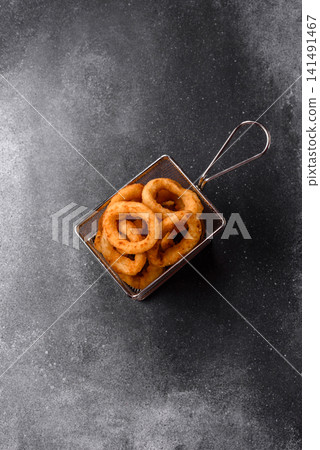 Deep fried breaded onion or squid rings, crispy fast food snacks. Fried onion or squid rings Deep fried breaded onion or squid rings, crispy fast food snacks. Fried onion or squid rings 141491467