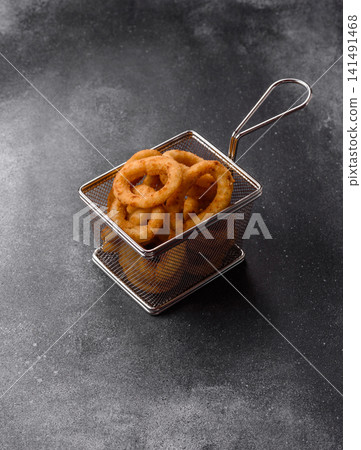 Deep fried breaded onion or squid rings, crispy fast food snacks. Fried onion or squid rings Deep fried breaded onion or squid rings, crispy fast food snacks. Fried onion or squid rings 141491468
