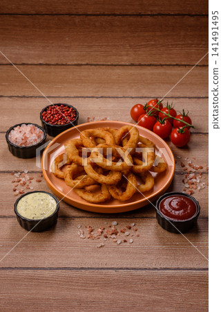 Deep fried breaded onion or squid rings, crispy fast food snacks. Fried onion or squid rings Deep fried breaded onion or squid rings, crispy fast food snacks. Fried onion or squid rings 141491495