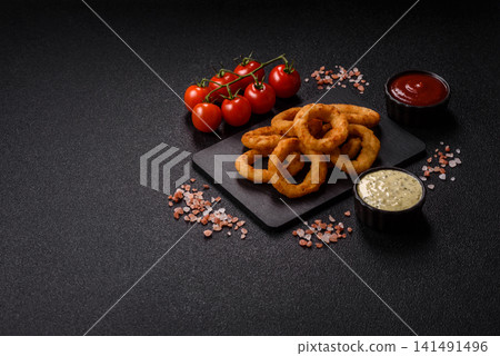 Deep fried breaded onion or squid rings, crispy fast food snacks. Fried onion or squid rings Deep fried breaded onion or squid rings, crispy fast food snacks. Fried onion or squid rings 141491496