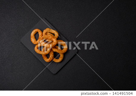 Deep fried breaded onion or squid rings, crispy fast food snacks. Fried onion or squid rings Deep fried breaded onion or squid rings, crispy fast food snacks. Fried onion or squid rings 141491504