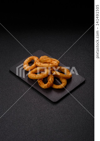 Deep fried breaded onion or squid rings, crispy fast food snacks. Fried onion or squid rings Deep fried breaded onion or squid rings, crispy fast food snacks. Fried onion or squid rings 141491505