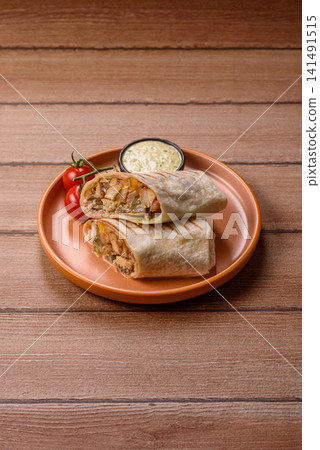 Grilled chicken shawarma or doner with tomatoes, cucumber, and sauces, takeout food Grilled chicken shawarma or doner with tomatoes, cucumber, and sauces, takeout food 141491515