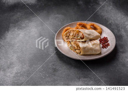 Grilled chicken shawarma or doner with tomatoes, cucumber, and sauces, takeout food Grilled chicken shawarma or doner with tomatoes, cucumber, and sauces, takeout food 141491523