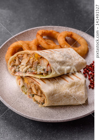 Grilled chicken shawarma or doner with tomatoes, cucumber, and sauces, takeout food Grilled chicken shawarma or doner with tomatoes, cucumber, and sauces, takeout food 141491527