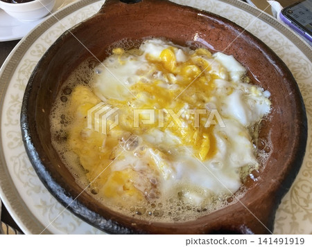 Traditional Moroccan Breakfast Eggs Cooked in Clay Pot Skillet Traditional Moroccan Breakfast Eggs Cooked in Clay Pot Skillet 141491919