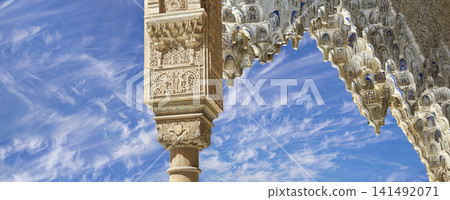 Arches in Islamic (Moorish) style (against the background of a beautiful sky with clouds) in Alhambra, Granada, Spain 141492071