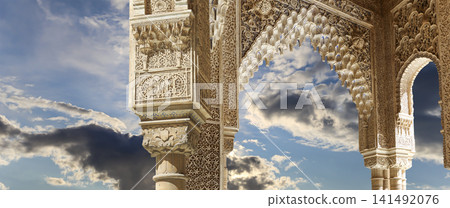Arches in Islamic (Moorish) style (against the background of a beautiful sky with clouds) in Alhambra, Granada, Spain Arches in Islamic (Moorish) style (against the background of a beautiful sky with clouds) in Alhambra, Granada, Spain 141492076