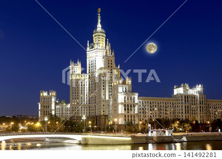 Kotelnicheskaya Embankment Building at night with the super moon, Moscow, Russia-- is one of seven stalinist skyscrapers laid down in September, 1947 and completed in 1952. Kotelnicheskaya Embankment Building at night with the super moon, Moscow, Russia-- is one of seven stalinist skyscrapers laid down in September, 1947 and completed in 1952. 141492281