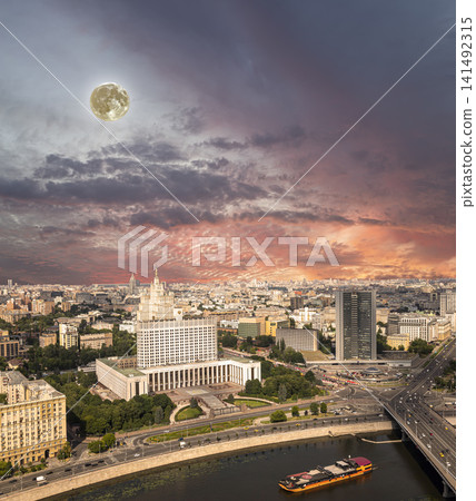 Aerial view of Moscow against the romantic evening sky with clouds and rays of the sun with the super moon. Government House of the Russian Federation (White House)-written in Russian, Russia Aerial view of Moscow against the romantic evening sky with clouds and rays of the sun with the super moon. Government House of the Russian Federation (White House)-written in Russian, Russia 141492315