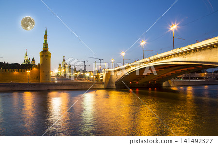 Night view of the Moskva River and Kremlin, Russia, Moscow (most popular view). Against the background of a beautiful sky with clouds, with the moon 141492327