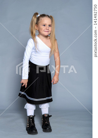 little girl shows off her bold and joyful personality with a playful pose, making the most of the studio setting. Her trendy one-shoulder top and pleated skirt add a stylish flair to the energetic little girl shows off her bold and joyful personality with a playful pose, making the most of the studio setting. Her trendy one-shoulder top and pleated skirt add a stylish flair to the energetic 141492750