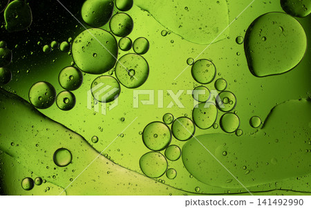 Green oil bubbles floating on water, forming an abstract macro background Green oil bubbles floating on water, forming an abstract macro background 141492990