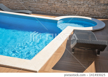 Modern swimming pool edge with sun loungers. Modern swimming pool edge with sun loungers. 141493025