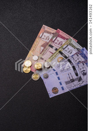 Saudi Arabia paper money, riyal banknotes and coins as currency for exchange. Saudi Arabia money Saudi Arabia paper money, riyal banknotes and coins as currency for exchange. Saudi Arabia money 141493162