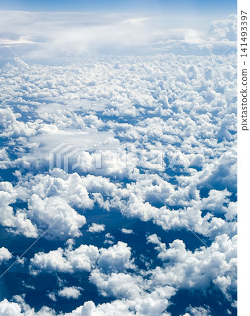 Many fluffy clouds scattered across blue sky during daylight top view from plane flying at high altitude. Clouds vary in size and shape, creating soft texture against vibrant blue background Many fluffy clouds scattered across blue sky during daylight top view from plane flying at high altitude. Clouds vary in size and shape, creating soft texture against vibrant blue background 141493397