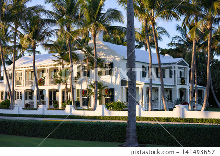 Daytime View Of Colonial House With Palm Trees And White Fence Daytime View Of Colonial House With Palm Trees And White Fence 141493657