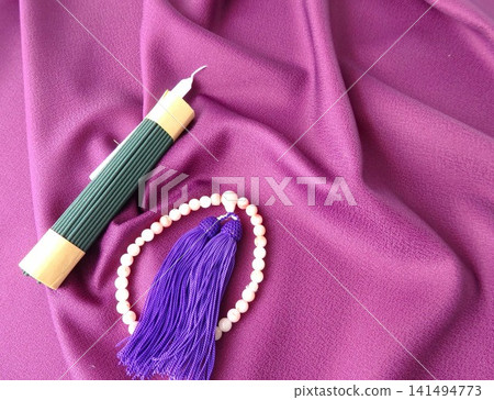 A purple background with prayer beads, candles, and incense sticks. A purple background with prayer beads, candles, and incense sticks. 141494773