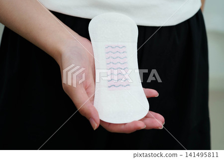 Asian woman holding sanitary napkin pad for hygiene menstrual period cycle protection. Asian woman holding sanitary napkin pad for hygiene menstrual period cycle protection. 141495811