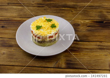 Traditional russian salad Mimosa on wooden table Traditional russian salad Mimosa on wooden table 141497281