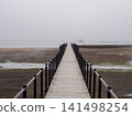 A wooden boardwalk leading to the sea 141498254