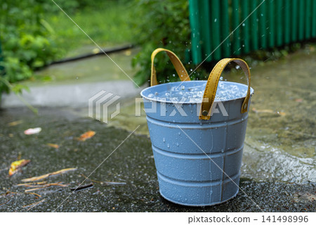 Concept of rainwater harvesting, water conservation, sustainable resource management, eco-friendly living and efficient use of natural rainfall. Storage container are visible under natural daylight 141498996