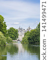 London's St. James's Park and its fountain, surrounded by blue skies and lush greenery. 141499471