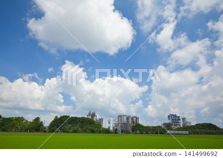 A train running through rural and industrial areas. A train running through rural and industrial areas. 141499692