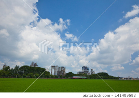 A train running through rural and industrial areas. A train running through rural and industrial areas. 141499698