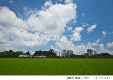 A train running through rural and industrial areas. A train running through rural and industrial areas. 141499717