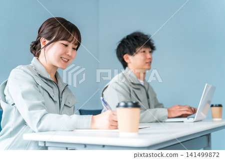 Businessmen and women in work clothes listening to a conference, meeting, or presentation Businessmen and women in work clothes listening to a conference, meeting, or presentation 141499872