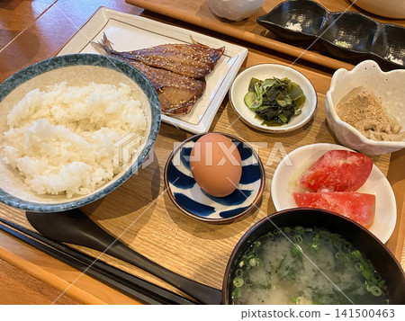 A traditional Japanese breakfast: a set meal consisting of grilled fish, a raw egg, and several small side dishes. A traditional Japanese breakfast: a set meal consisting of grilled fish, a raw egg, and several small side dishes. 141500463