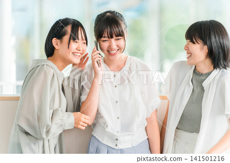 兩名小學和國中女生在用智慧型手機聊天 兩名小學和國中女生在用智慧型手機聊天 141501216