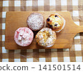 Wooden cutting board and muffins 141501514